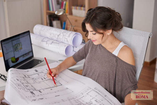 Foto di architetto al lavoro nel suo afficio arredato grazie al suo domicilio professionale