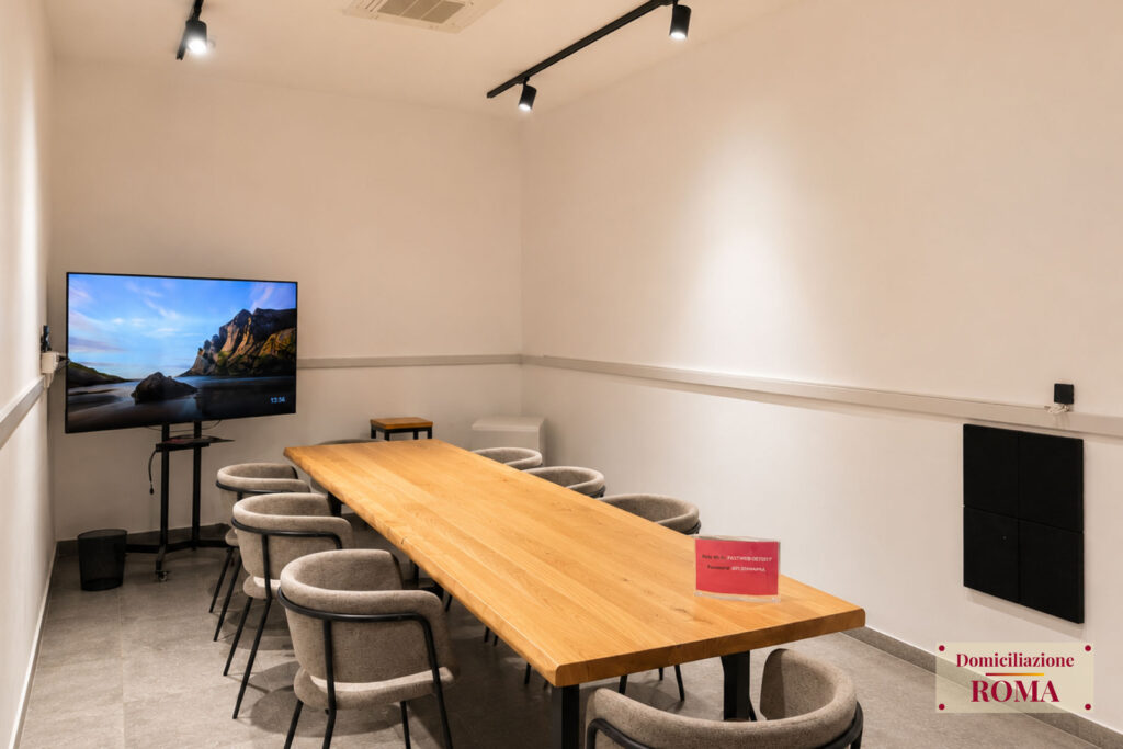Sala riunioni con tavolo in legno e smart TV nel Business Center di Pomezia