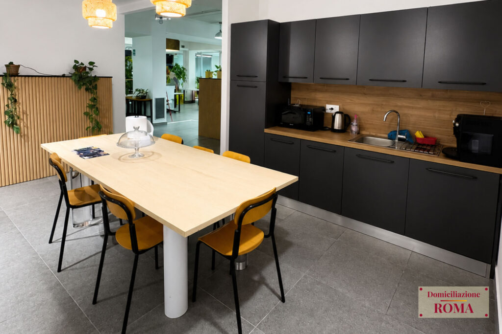 Cucina condivisa con tavolo comune nel coworking di Pomezia