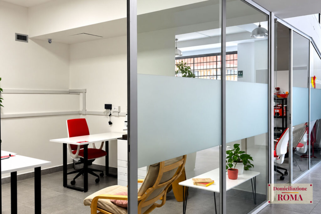 Uffici con pareti vetrate e postazioni nel coworking di Pomezia